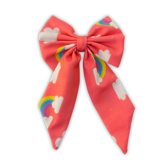 Rainbow Cloud Midi Tail Hair Bow by RedBerry Cuddle. A whimsical and colorful hair accessory featuring a midi-length bow with a dreamy rainbow and cloud design, crafted from high-quality fabric for a secure and charming look.