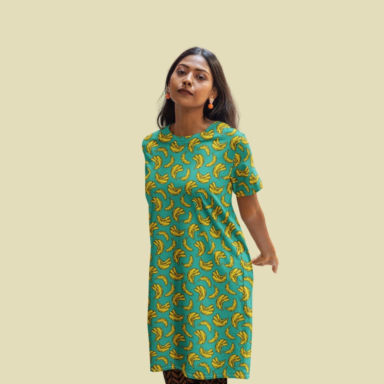 Banana Women's T-shirt Dress by RedBerry Cuddle, featuring a playful banana design. Made from fade-proof fabric, it includes two convenient pockets for added comfort and style.